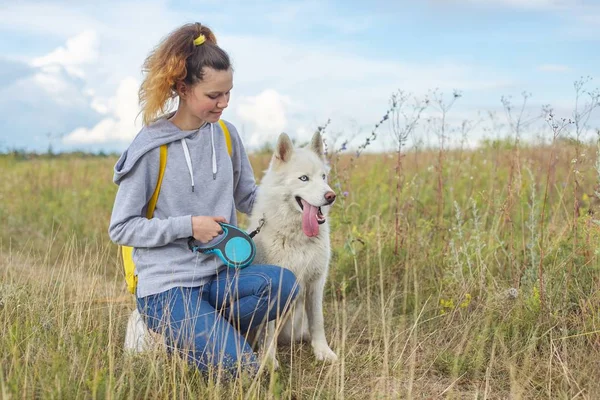 Vacker flicka med vit hund, tonåring promenader med husky husdjur — Stockfoto