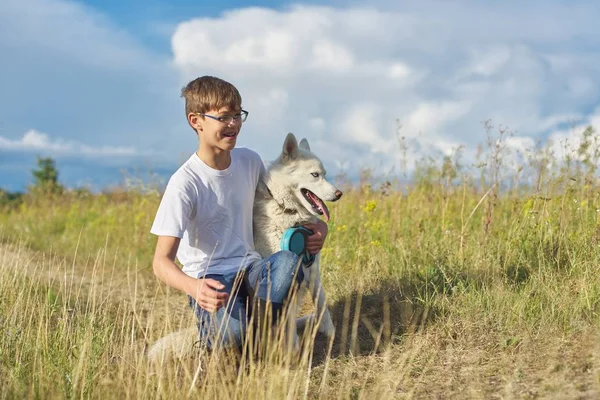 Garçon avec chien blanc, adolescent marchant avec animal de compagnie husky — Photo