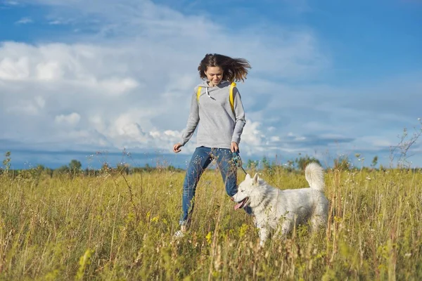 Mode de vie sain actif, jeune fille courir avec chien blanc husky — Photo
