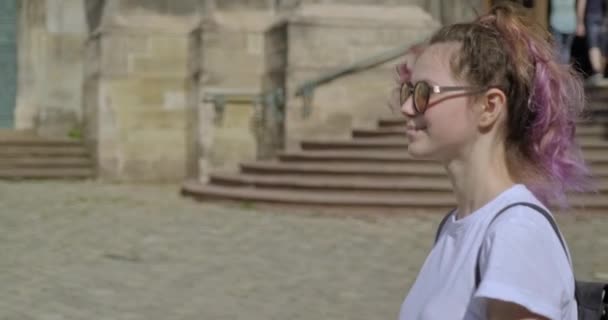 Krásná usmívající se mladá dívka s batohem chůze v turistickém starém městě — Stock video