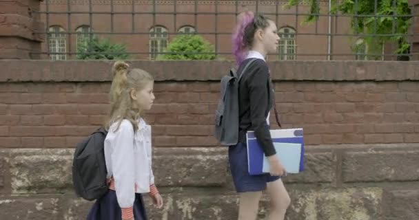 Two girls going to school, children in school uniform with backpacks — Stock Video