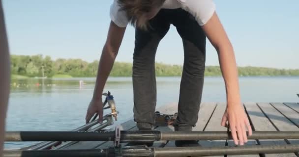 Jongens 15, 16 jaar oud peddelen sport kajak. Tieners stappen uit de boot, vouwen riemen — Stockvideo