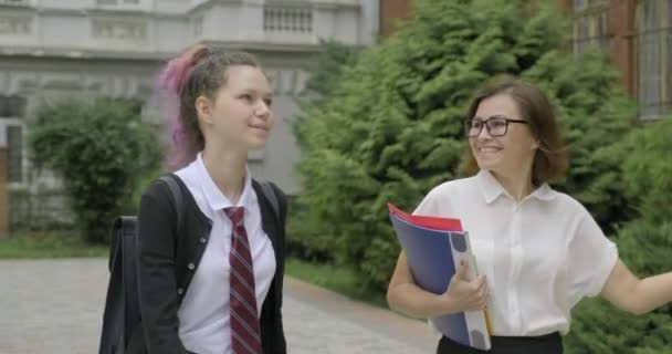 Женщина учитель и девочка подросток старшеклассник ходить — стоковое видео