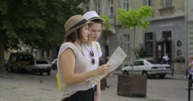 Yaşlı bir turist şehrinde haritası olan anne ve genç bir kız.