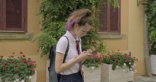 Hermosa estudiante adolescente con teléfono inteligente de lectura y escritura de mensajes de texto — Vídeos de Stock