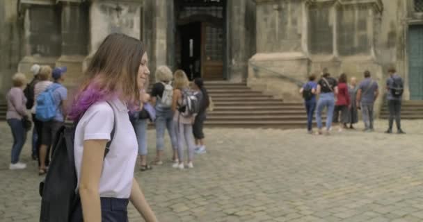 Mooie glimlachende jonge tiener meisje met rugzak wandelen in toeristische oude stad Lviv — Stockvideo