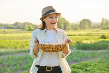 Taze yumurta sepeti ile Olgun güzel kadın çiftçi,