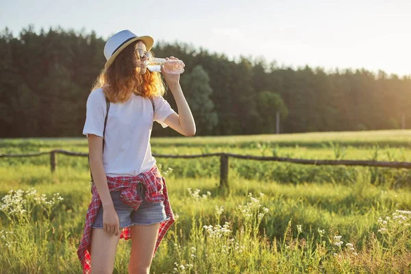 Young walking teen girl drinking water from bottle — Stock Photo, Image