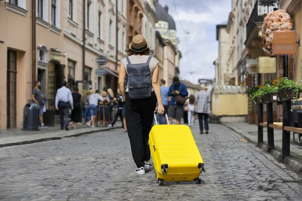 Podróżująca kobieta turystka w kapeluszu z plecakiem i walizką spaceru — Zdjęcie stockowe