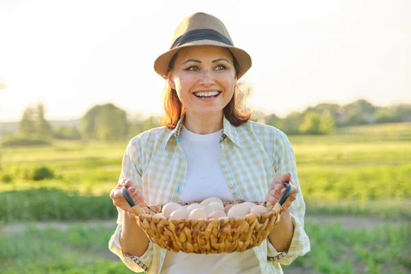 Mogen vacker kvinna bonde med korg av färska ägg, — Stockfoto