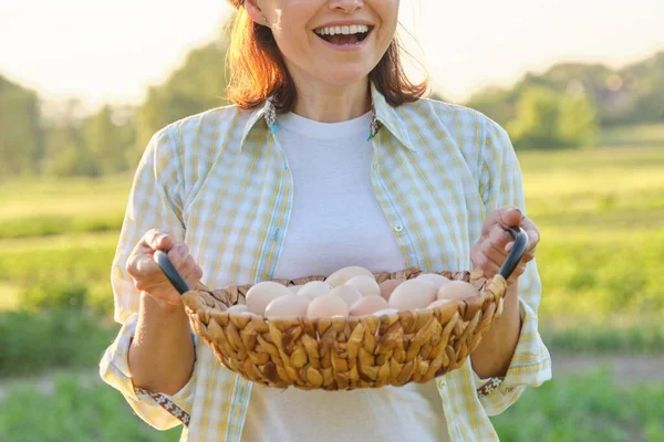 Çayırda yumurta sepeti olan olgun bir kadının taşralı portresi. — Stok fotoğraf