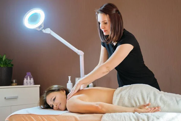 Volwassen volwassen vrouw rusten op rug massage procedure op massage tafel in schoonheidssalon — Stockfoto