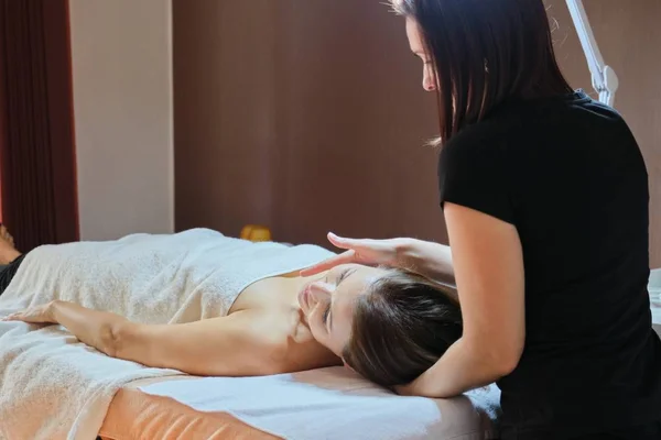 Mulher madura deitada na mesa de massagem e recebendo massagem médica — Fotografia de Stock