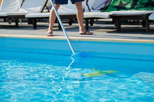 Limpieza masculina piscina al aire libre con tubo de vacío bajo el agua —  Fotos de Stock