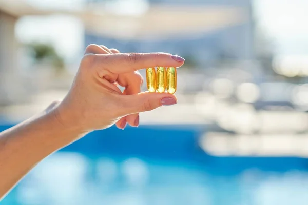 Vitamine D, E, A visolie capsules kabeljauw lever olie omega 3 in vrouwelijke hand — Stockfoto