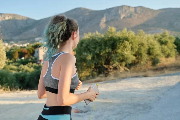 Koşan fitness kızı, dağlarda yol, arka manzara, kopyalama alanı — Stok fotoğraf