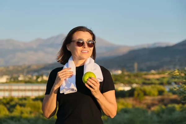 Gammal kvinna äter äpple, kvinnor hälsosam livsstil — Stockfoto