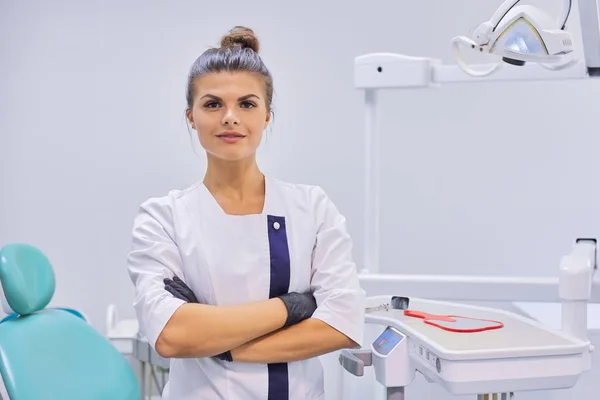 Jonge positieve vrouwelijke tandarts arts met gevouwen armen — Stockfoto