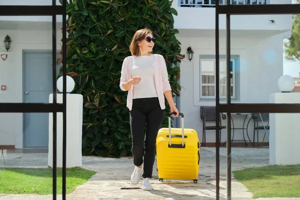 Mujer adulta con equipaje con maleta que va al vestíbulo del hotel — Foto de Stock