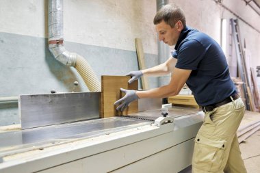 Marangoz, marangozhanede makine kullanıyor.