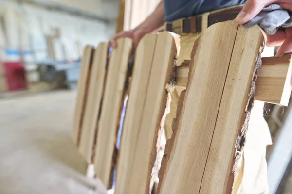 Erkek marangoz marangozlukta yeni yapılmış ahşap çitleri gösteriyor. — Stok fotoğraf