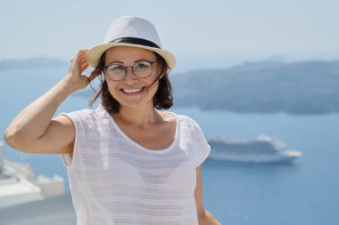 Gülümseyen kadın Santorini Adası 'ndaki kameraya bakıyor.