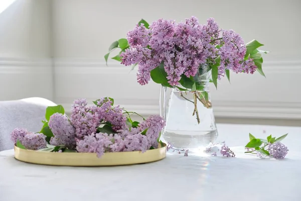 Ramo de flores de primavera de color lila en jarra de vidrio en la mesa — Foto de Stock