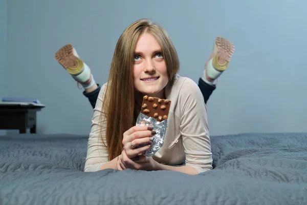 Rolig känslomässig flicka håller mjölk choklad med hela nötter i handen — Stockfoto