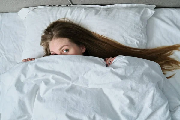 Молода красива жінка лежить на подушці в ліжку, вид зверху — стокове фото