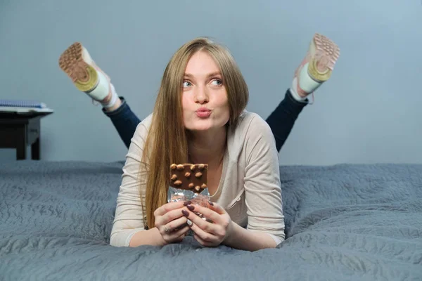 Rolig känslomässig flicka håller mjölk choklad med hela nötter i handen — Stockfoto