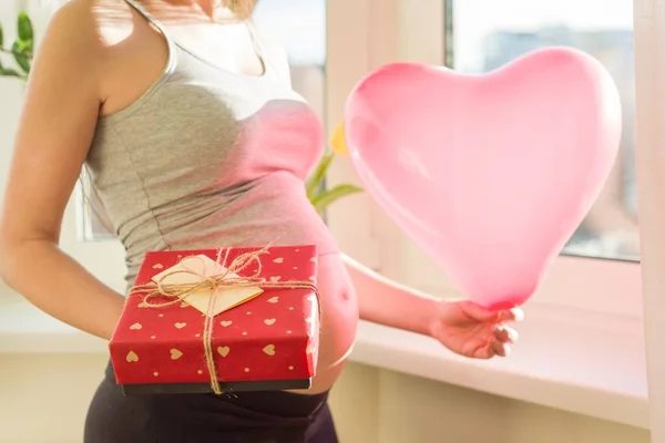 Mujer embarazada con caja de regalo y corazón de globo —  Fotos de Stock