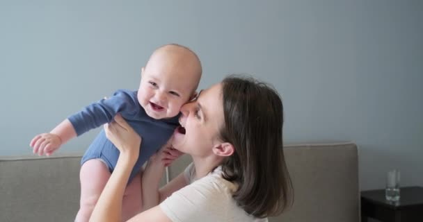 Happy laughing mother and baby, infant boy in arms of young beautiful mother — Stock Video