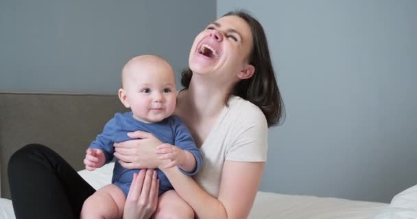 Feliz rindo mãe e bebê, menino nos braços da jovem mãe bonita — Vídeo de Stock