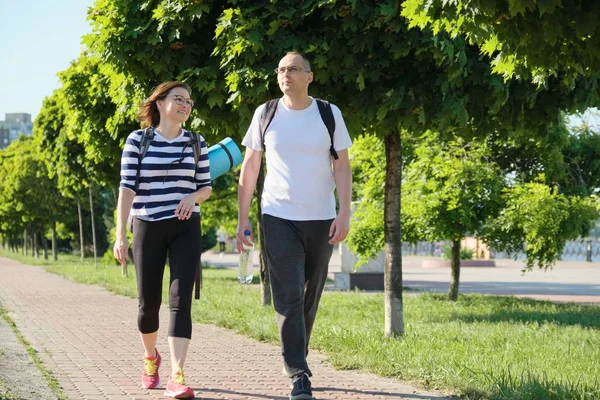 Μιλούν μεσήλικας άνδρας και γυναίκα, ζευγάρι περπατά κατά μήκος του δρόμου πάρκο — Φωτογραφία Αρχείου