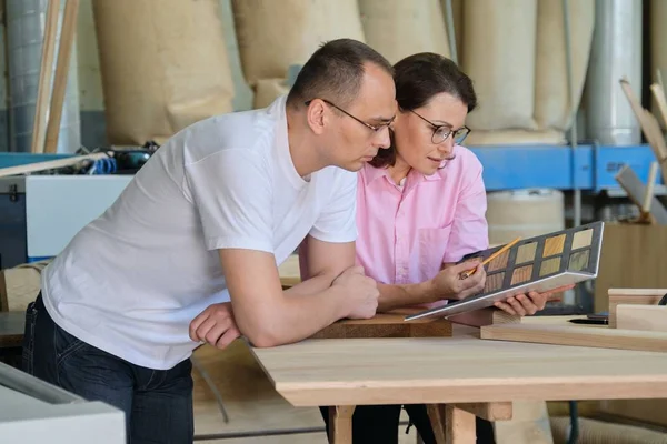 Man and woman choosing finish processing of wooden furniture — Stock Photo, Image