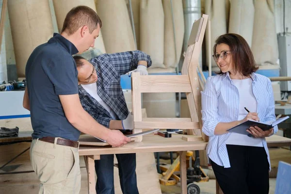 Woman and men workers making sample of wooden chair — Stock Photo, Image