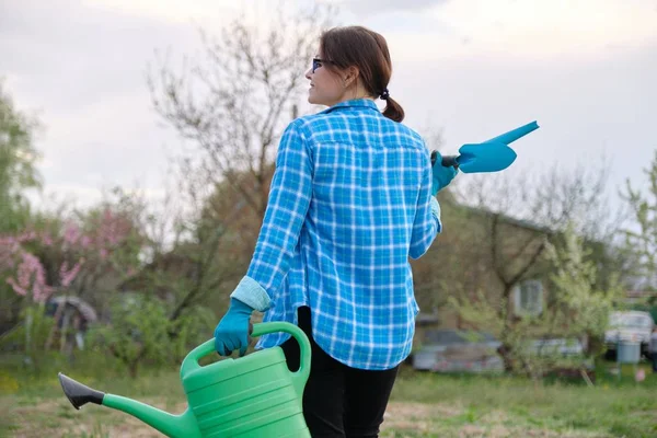 Perempuan tukang kebun memegang kaleng air dan alat-alat kebun — Stok Foto