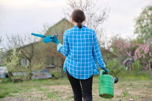 Perempuan tukang kebun memegang kaleng air dan alat-alat kebun — Stok Foto