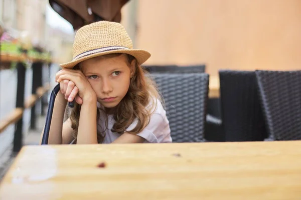 Retrato de niña aburrida infeliz cansada sentada en la cafetería al aire libre — Foto de Stock