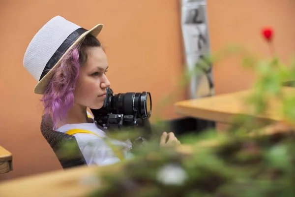 Tiener meisje met camera zitten in een stad outdoor cafe — Stockfoto