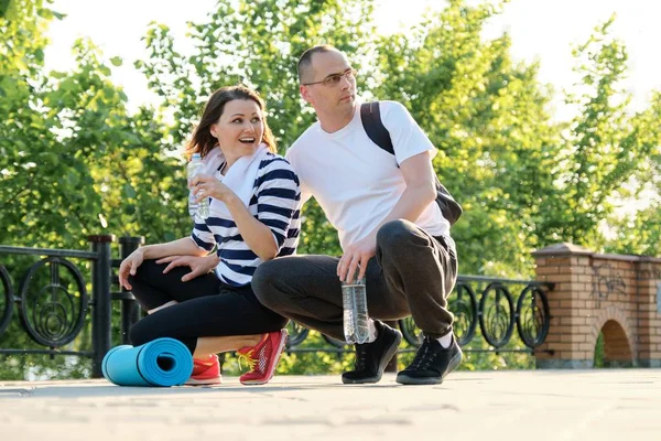 Glad leende mogna par sitter i parken, prata vila efter att ha gjort sport — Stockfoto