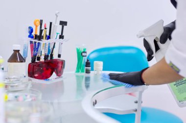 Kyiv Ua, 31-07-2019. Dişçi doktorlarının yüzeyi sterilize eden hemşire elleri.