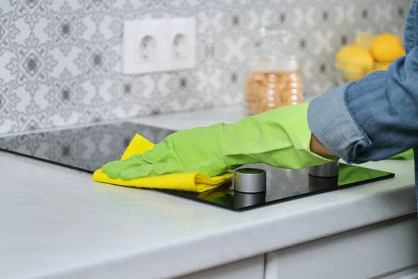 Женщина руки в перчатках стирка и чистка электрическая плита на кухне — стоковое фото