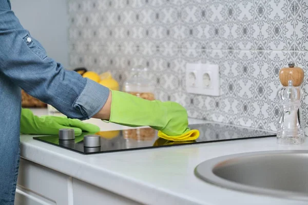 Mujer en guantes con trapo cocina de limpieza, lavado de encimera eléctrica — Foto de Stock