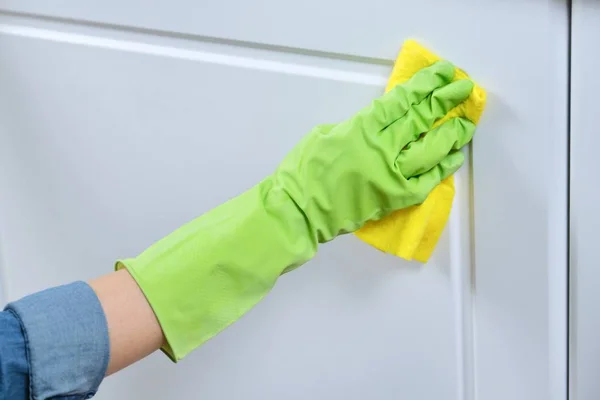 Vrouw in handschoenen met vodden wassen, schoonmaken, polijsten meubeldeuren — Stockfoto