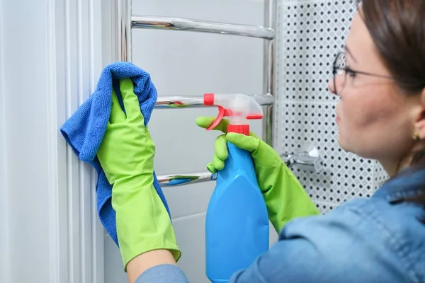 Schoonmaken badkamer, vrouw polijsten verwarmde handdoek rail — Stockfoto