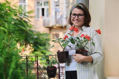 Kırmızı yaz çiçekleri olan güzel olgun bir kadın.