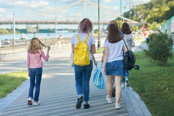 Ludzie spacerujący, widok z tyłu, nastolatki i dzieci spacerujące chodnikiem — Zdjęcie stockowe