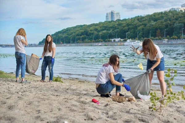 Nastolatki sprzątające plastikowe śmieci w naturze, brzeg rzeki — Zdjęcie stockowe