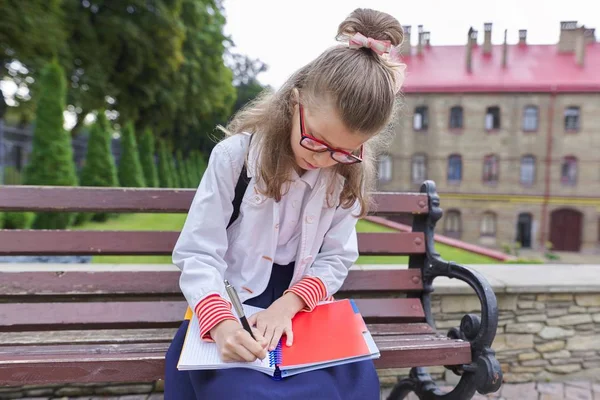 Torniamo a scuola. Ritratto esterno di girll con zaino scritto su taccuino — Foto Stock